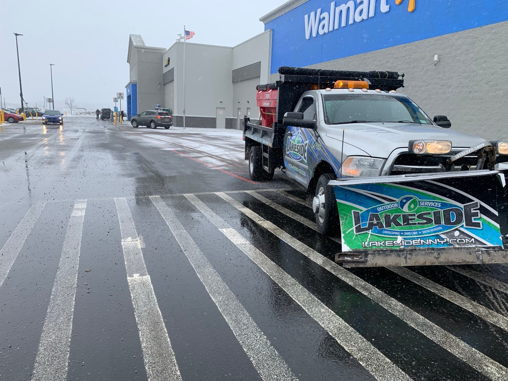 Lakeside plow truck servicing a commercial parking lot
